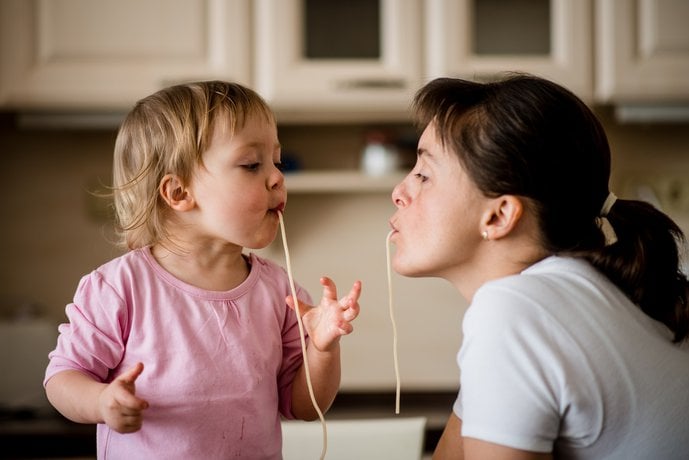 mother and daughter eating spaghetti
